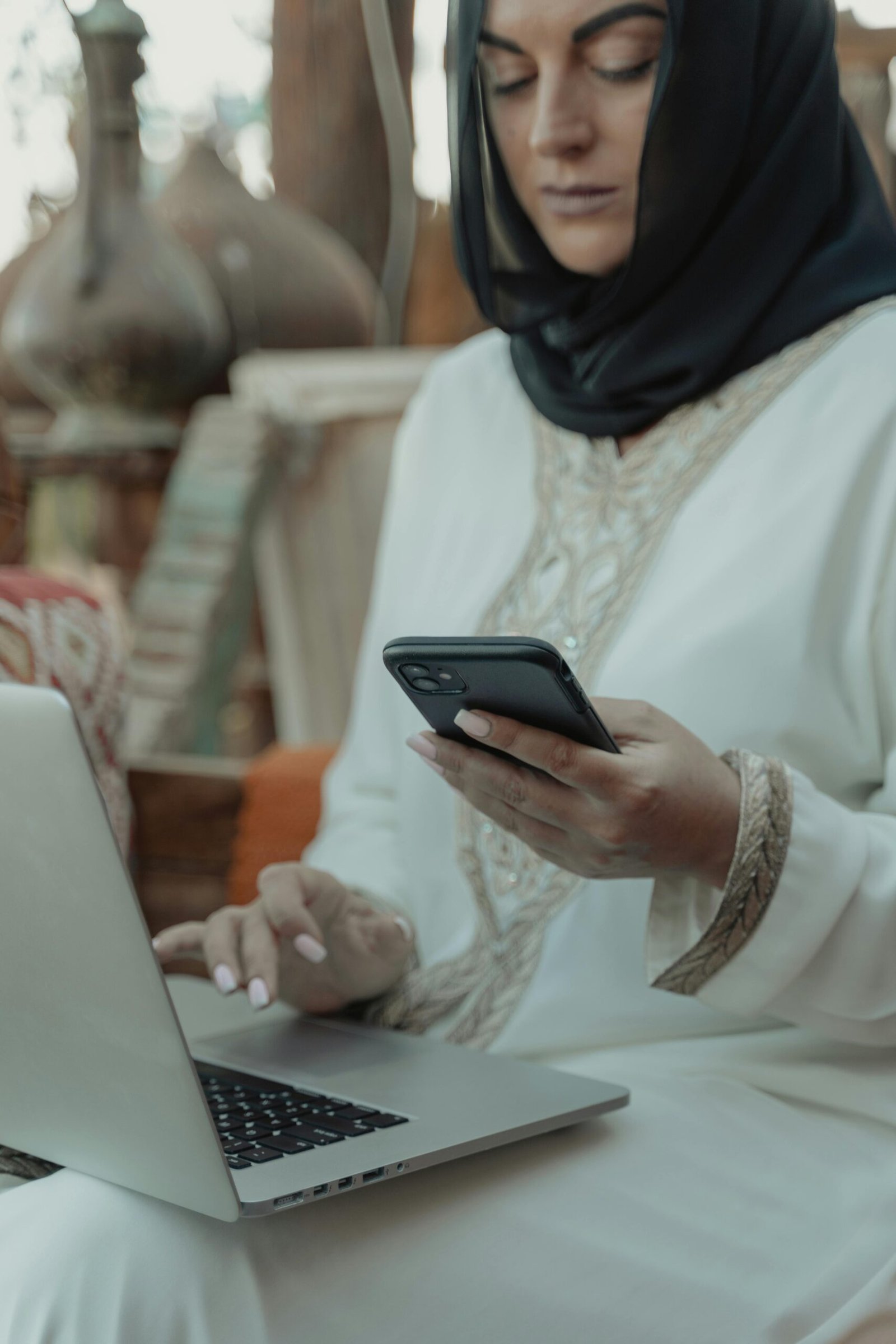 Hijabi using muslim dating websites on her phone and laptop